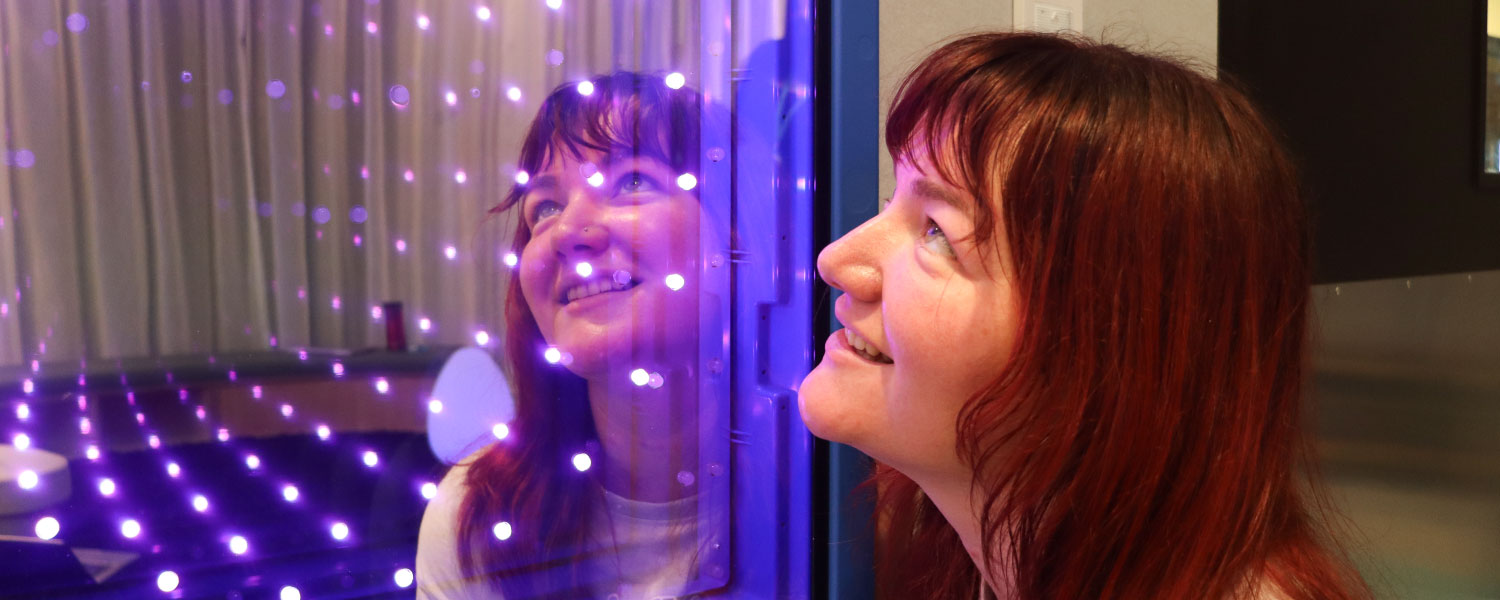 Person engaging with sensory lighting in the Sensory Space.