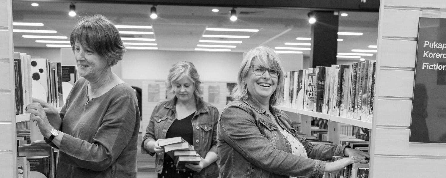Library users browsing bookshelves in the library.