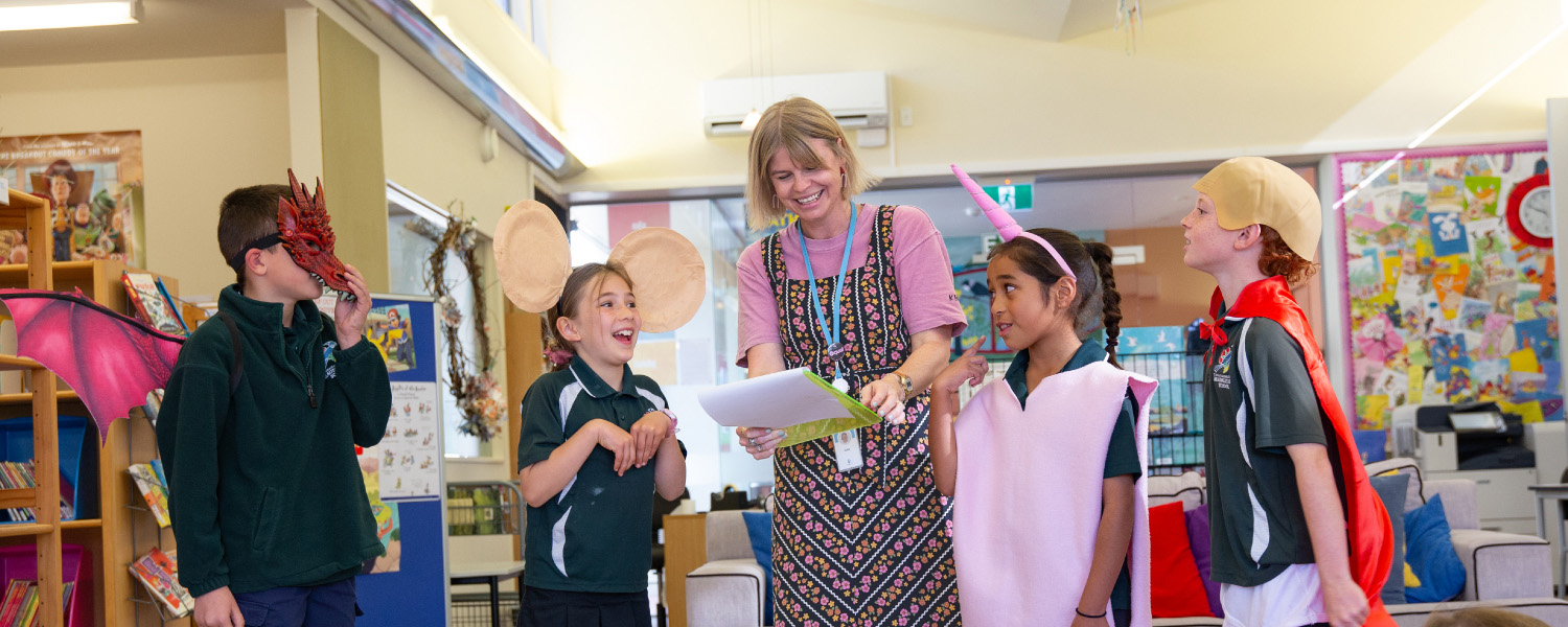 Students in costume take part in an interactive learning activity with an educator.
