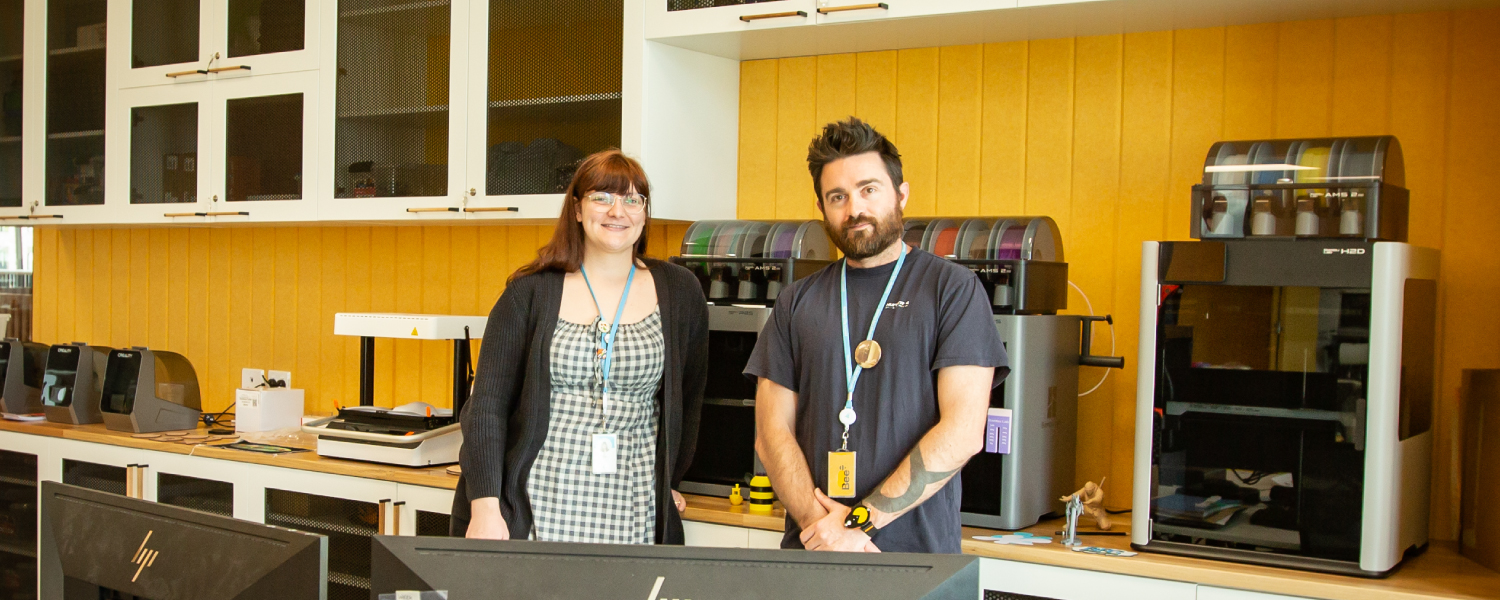 Creation station staff standing beside 3D printers at the Creation Station.