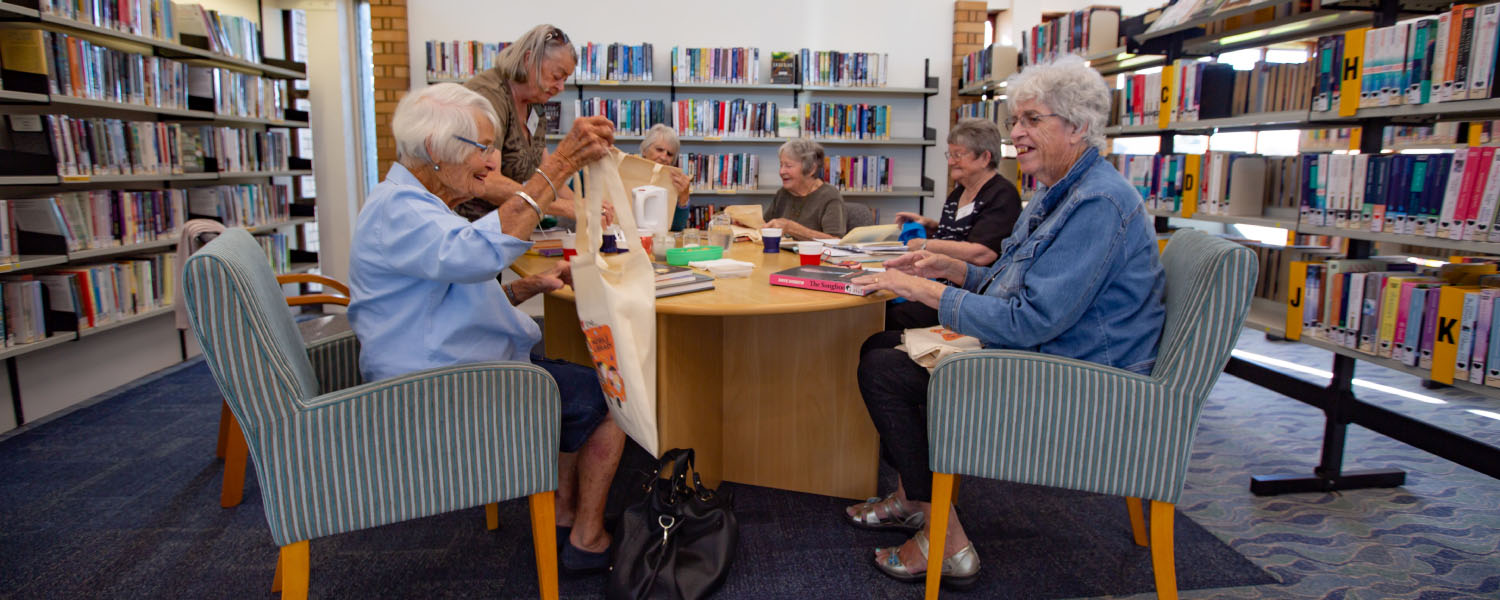 Library members discussing books during a book chat session.