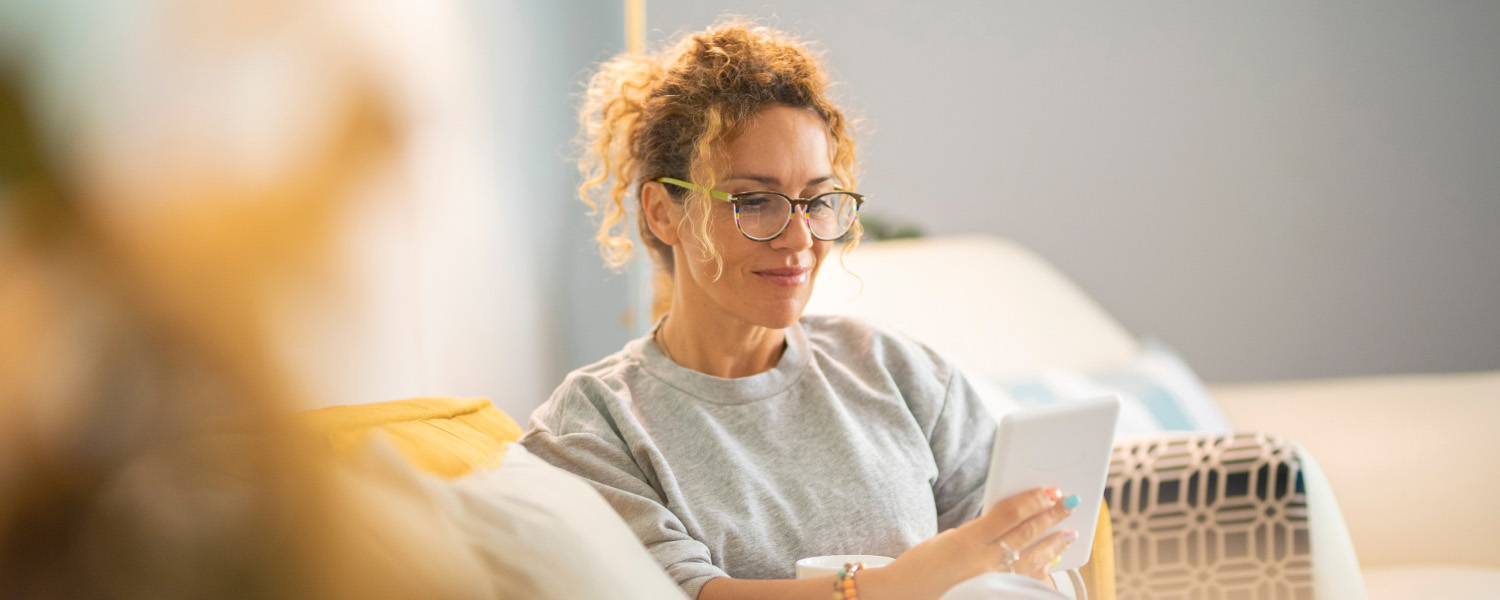 Person reading on a tablet at home.